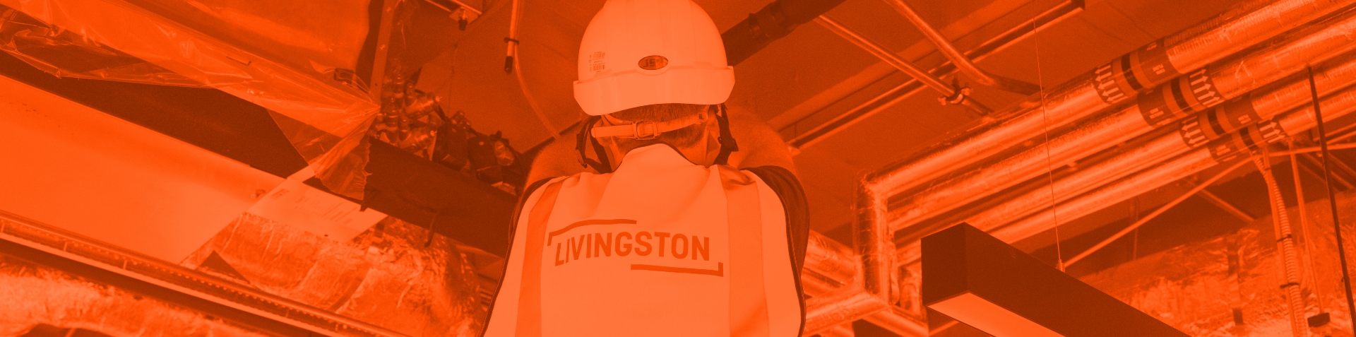 A LivingstonME staff member working on industrial equipment and piping